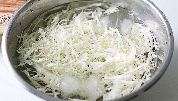 Trước hết, bạn thái nhỏ rồi rửa sạch bắp cải, ngâm trong nước đá vài phút để chúng giòn hơn. Sau đó vớt bắp cải ra rổ cho ráo nước.