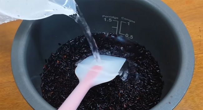 Ước lượng nước bằng lượng gạo rồi cho vào nồi cơm điện với ít muối